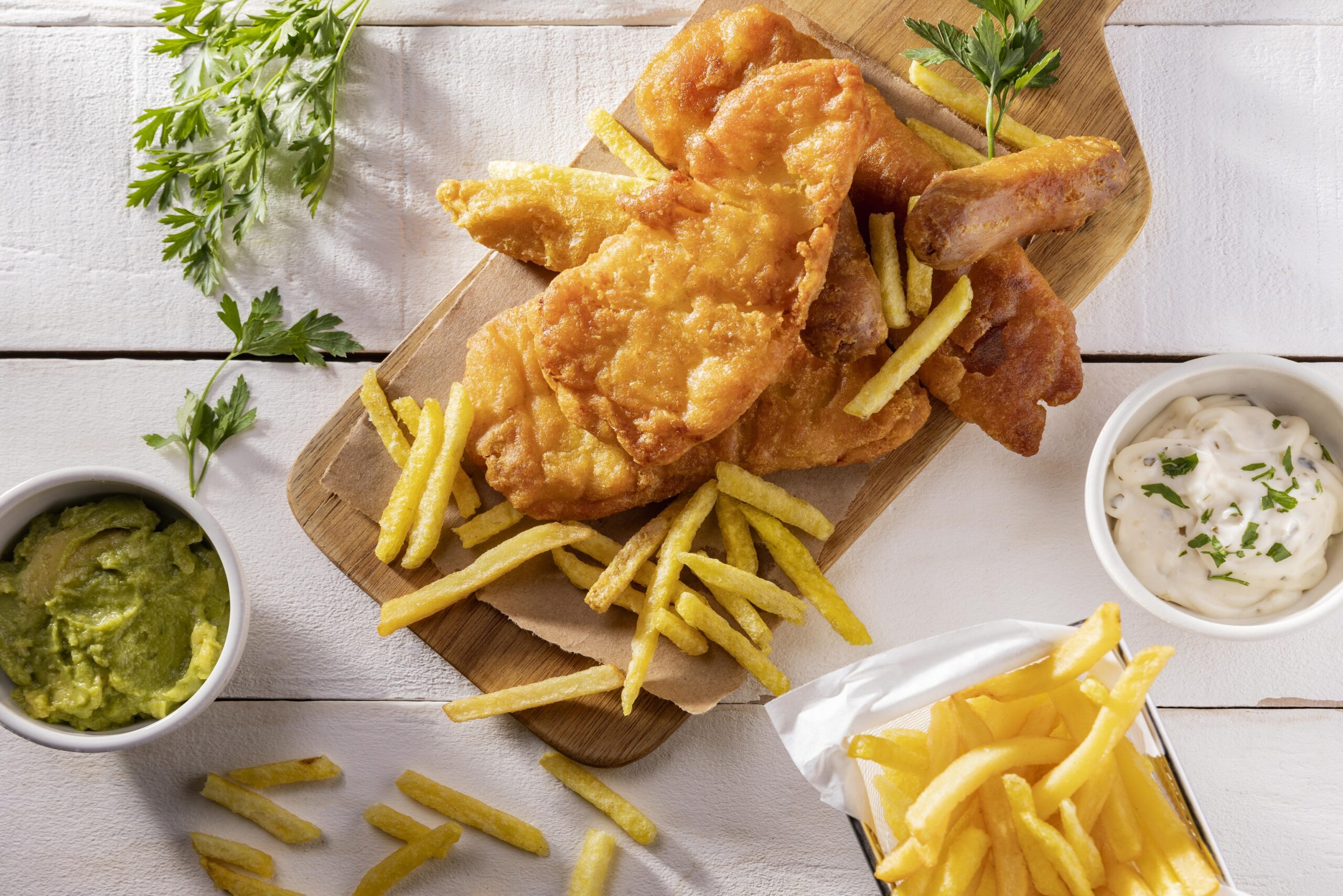 flat-lay-fish-chips-chopping-board-with-sauce